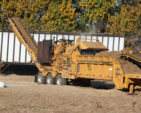 Photograph of feedstock being ground and loaded onto a conveyor belt. Courtesy Idaho National Laboratory