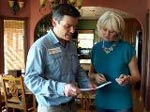 A photo of a man and a woman looking at plans for a home.