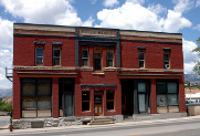 Photo of a large, brick building facade with blue skies beyond.
