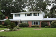 Photo of a split-level home with its lawn spread out in front of it.