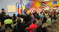 A photo of a speaker in front of a crowd.