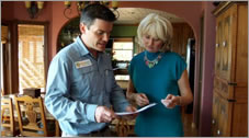 A photo of a man and a woman looking at plans for a home.