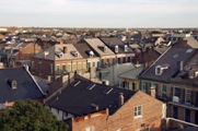 Photo of a cluster of houses, shot from above, also showing the sky.