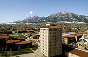 Photo of buildings spread across a landscape with mountains in the background.