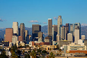 Photo of the Los Angeles skyline in the daytime, with many tall buildings in a downtown cluster.