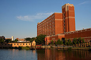 Photo of tall buildings and a river in the foreground.