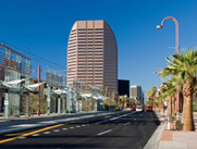 Photo of a city street, with a tall building in the background.