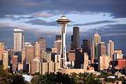Photo of the Seattle city skyline, with a variety of tall buildings clustered together.