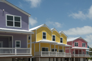 Photo of a row of houses with similar design but in varying colors.