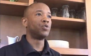 Photo of head and shoulders of a man facing a camera off-screen.