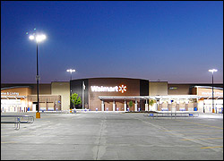 Photo of the exterior of a Walmart store at dusk with parking lot lights illuminated.