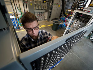 Photo of NREL researcher Jeff Tomberlin working on a data acquisition panel at the Building Efficiency Data Acquisition and Control Laboratory at NREL's Thermal Test Facility.