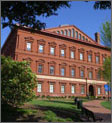 Photo of the exterior of the National Building Museum. The Museum is a three-story brick building with rows of windows on each story.