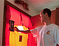 Photo of a man standing in front of a door performing a blower door test.