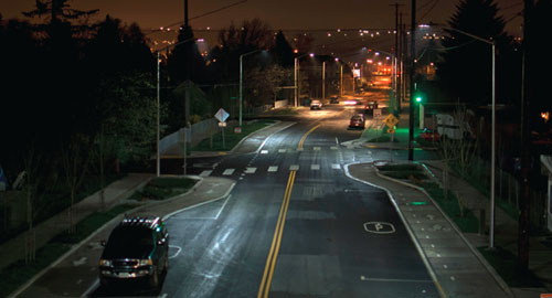 Photo of a road at night with streetlights on either side.