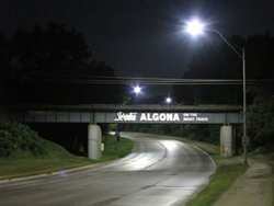 photo of a roadway and overpass at night lit with LED streetlights.