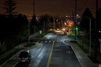 Photo of a street at night with cobrahead street lights on each side.