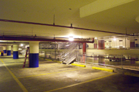 Photo of a parking garage interior with an LED ceiling light fixture at center.