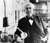 Black and white photo of Thomas Edison holding a light bulb.