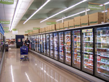 Photo of a row of freezer cases with LED lighting at a supermarket.