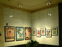 Photo of a corporate lobby with LED track lights illuminating eight framed pieces of art.