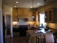 Photo of a kitchen with lit downlights.