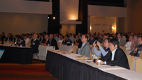 Photo of a hotel ballroom with seated workshop attendees.