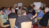 Photo of groups of people sitting at round tables.