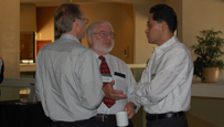 photo of three men in conversation.