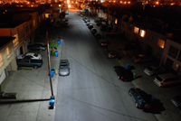 Aerial photo of a residential street at night, with LED street lights on the left side and high-pressure sodium street lights on the right.