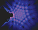 Picture of a lot of pink dots with light blue background in somewhat of a star formation, with darker blue and black spots around the edges.