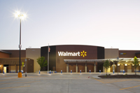 Photo of a Walmart store front with an LED parking lot luminaire at left.
