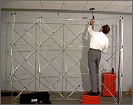 Photo of a man attaching lights to an exhibit display frame.