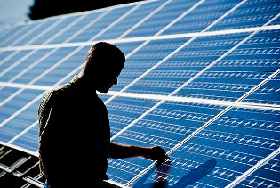 A man silhouetted against a background of solar panels