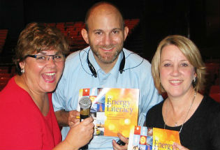 EERE's Sharon Cosgrove and Josh Sneideman stand with a middle school science teacher, all holding up Energy Literacy booklets.