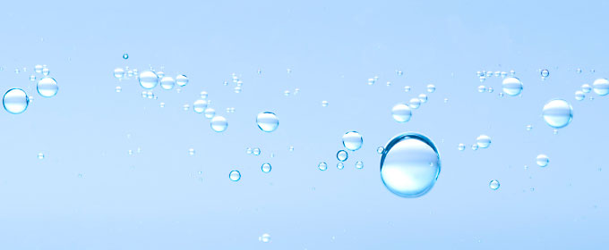 Photo of droplets of water against a pale blue background.