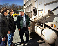 Photo of men standing beside a garbage truck