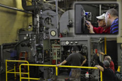 This composite photo shows technicians observing operation at the monitoring station and making subsequent fine adjustments on combustion system controls