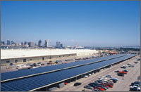 Photo of photovoltaic paneled carports at Navy Public Works Center with cityscape of San Diego in background.