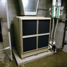 Photo of a geothermal heat pump unit on a concrete floor.
