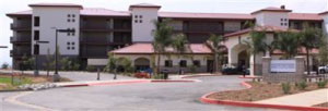 Picture of a Spanish-style building with xeriscape, including palm trees.