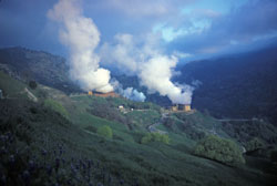 Photo of steam rising high in the air from a geyser.