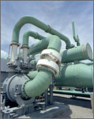 Photo of green pipes connecting into a facility.