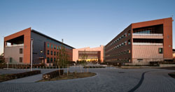 Photo of a large, brown, u-shaped office building with many windows