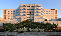 Photo of the Portland VA Medical Center shows a large beige building with a flag and several trees standing out front.