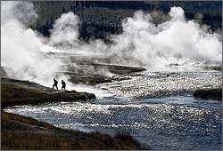 Photo of two men walking away from a natural steam pool.