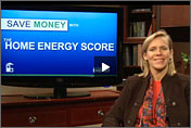 Screenshot from the video of Cathy Zoi sitting in front of a screen that reads, 'Save Money with the Home Energy Score.'