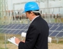 Image of a man with a clipboard, wearing a hard hat.