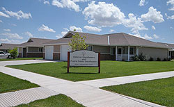 Photo of new ranch-style townhomes with nicely landscaped lawns, new trees, and sidewalks. A sign in front reads "Oakview Townhomes and Prairie Pointe Townhomes."