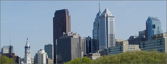 Photo of the Philadelphia skyline with a blue sky visible in the background.